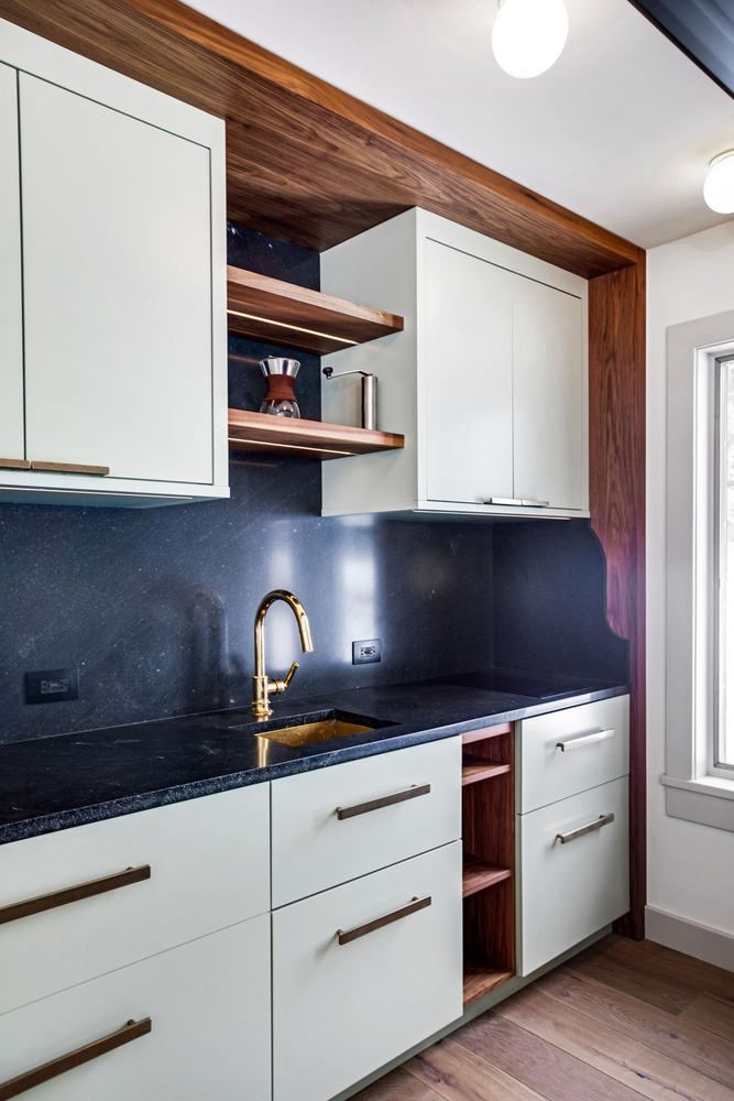Kitchenette with black counter and oak shelves