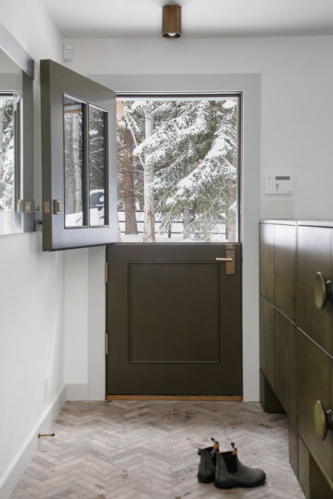 Mudroom in green, herringbone tile, Dutch door