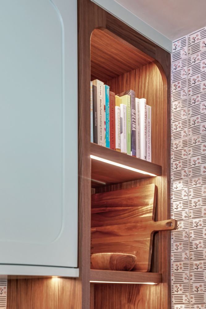 Lit walnut shelving in a painted surround
