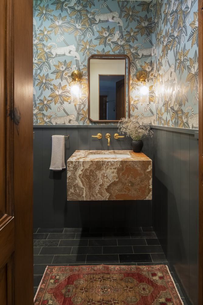 Powder room with onyx basin and dark paneling